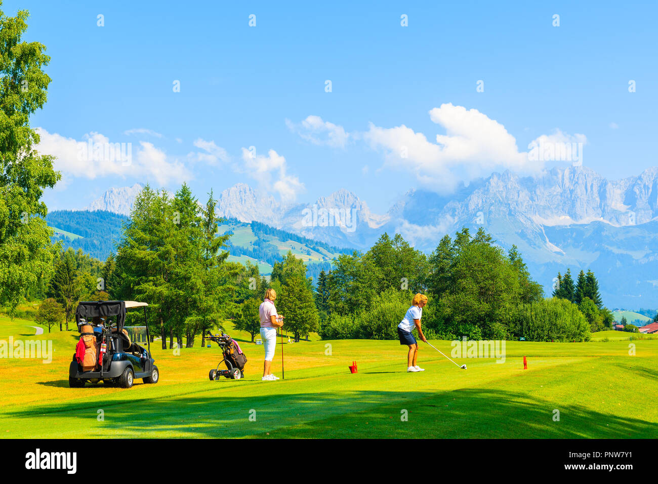 KITZBUHEL TOWN, AUSTRIA - AUG 3, 2018: Woman playing golf in Kitzbuhel club in summertime. It is popular Austrian holiday destination in summer. Stock Photo