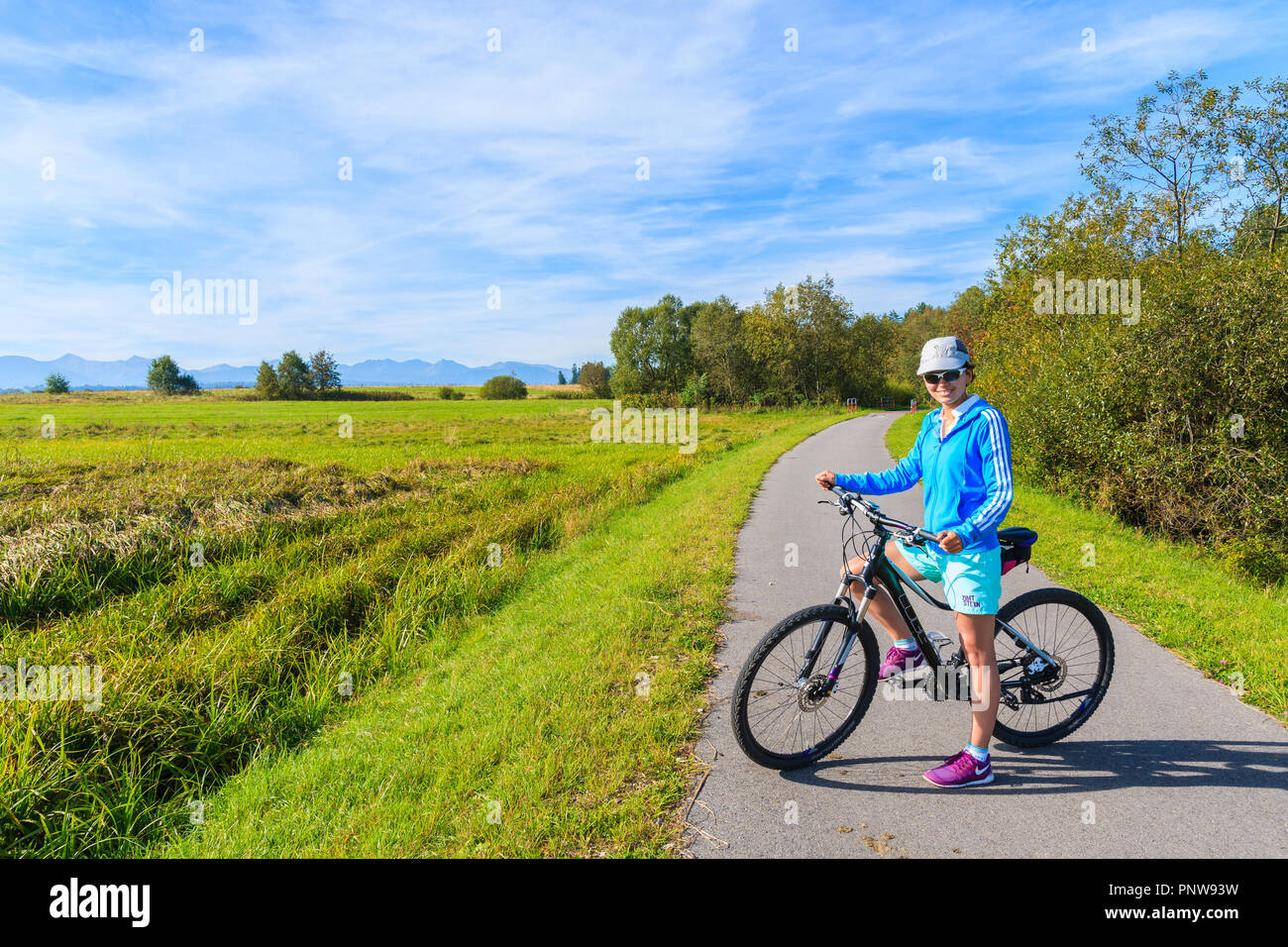 CZARNY DUNAJEC, POLAND - SEP 12, 2018: Young woman with bike on cycling track around Tatra Mountains near Czarny Dunajec village. The end point is in  Stock Photo