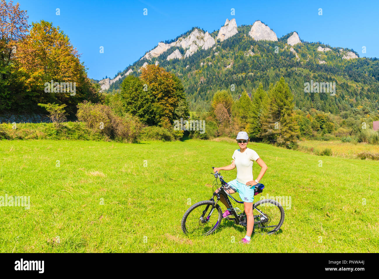 PIENINY MOUNTAINS, POLAND - SEP 19, 2018: Young woman cyclist near Trzy Korony (Three Crowns) on sunny autumn day. This mountain range is famous touri Stock Photo