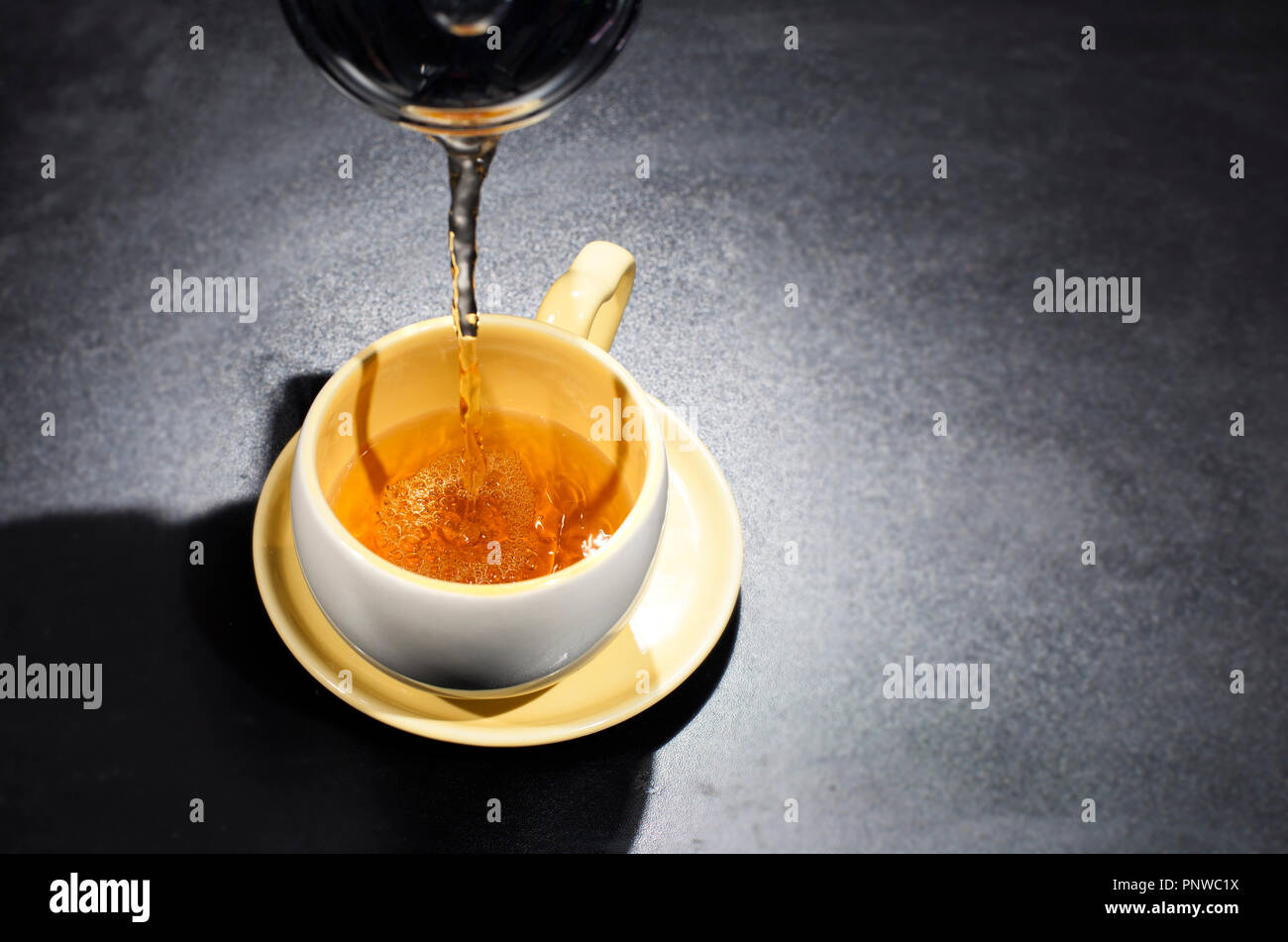 Pouring tea into a cup Stock Photo Alamy