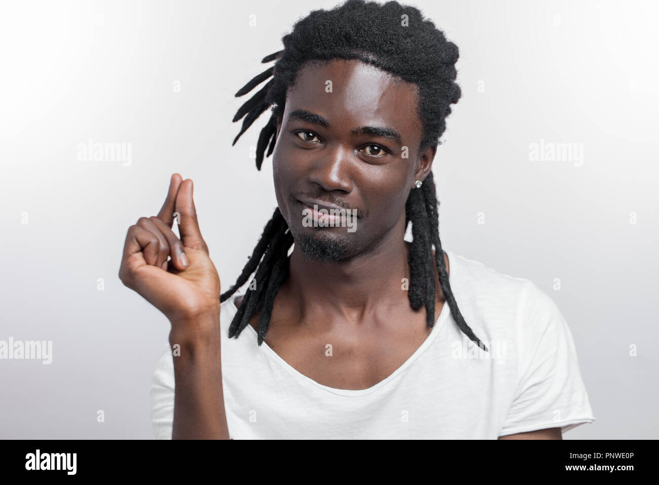 Dark Skinned Man Showing Small Thing While Smiling And Standing