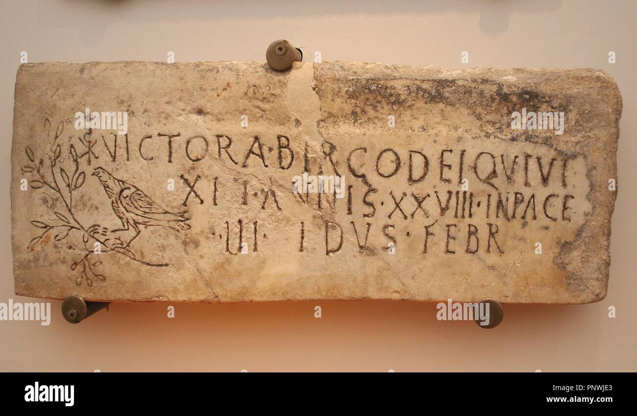 Early Christian Art. Italy. Early Christians. Roman tombstone with Christian iconography. Inscription: Victoria, consecrated virgin, who lived 28 years. Christian phrase appears 'in pace'. The symbol of the dove and the olive branch and the monogram of Constantine T. 4th century AD. Baths of Diocletian, part of the National Roman Museum Rome. Italy. Stock Photo