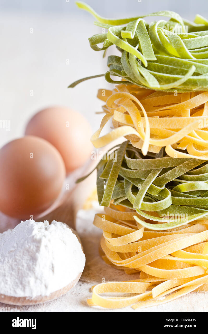 italian pasta tagliatelli, flour and eggs closeup on wooden board Stock Photo