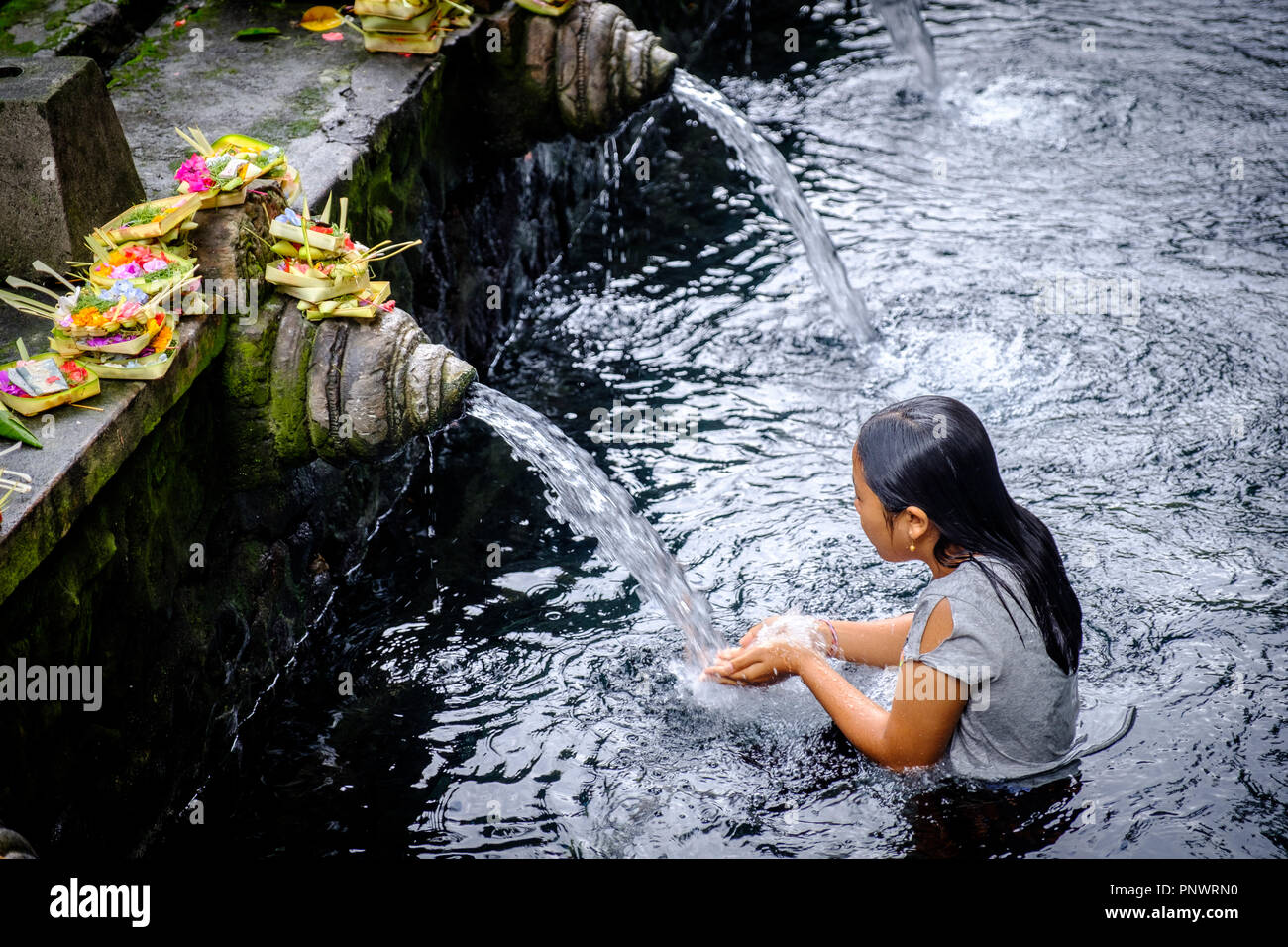 Balinese people taking a ritual purifying bath in holy spring water at Pura Tirta Empul Stock Photo