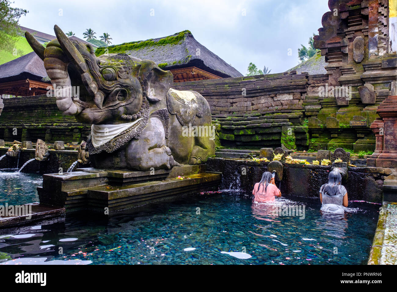 Balinese people taking a ritual purifying bath in holy spring water at Pura Tirta Empul Stock Photo