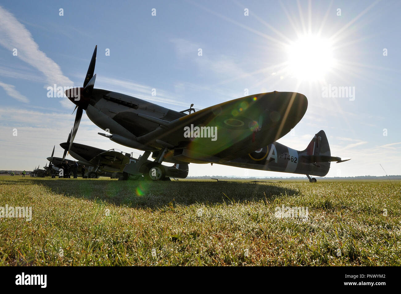 Supermarine Spitfire early in the moring on a sunny summer day with sun burning down behind. Second World War fighter plane. Dew on ground Stock Photo