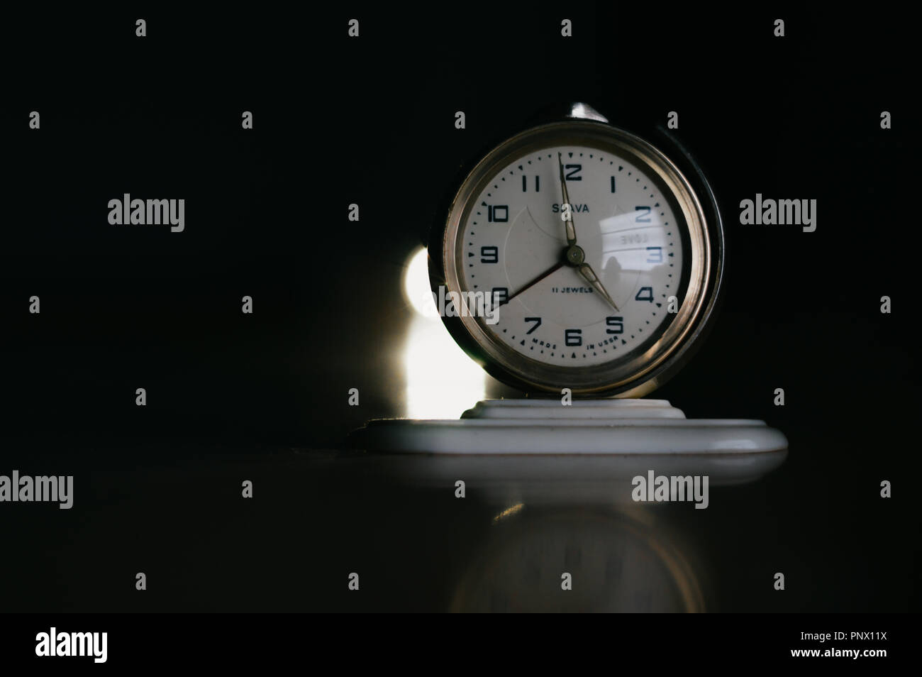 Vintage clock that has a spotlight from its back Stock Photo Alamy