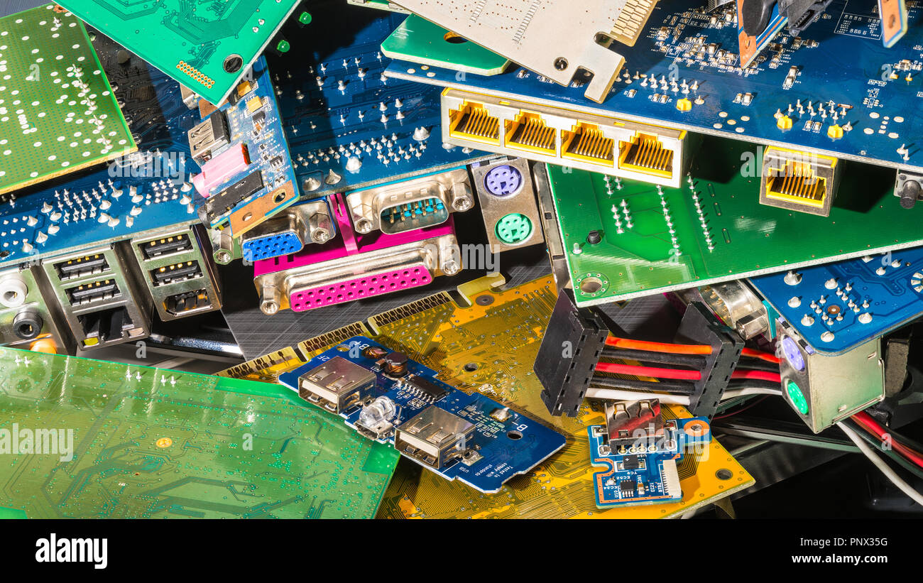 E-waste pile from discarded computer parts. Colorful background from PC components - mainboards, PCB, connectors. Hardware, electronics industry, eco. Stock Photo