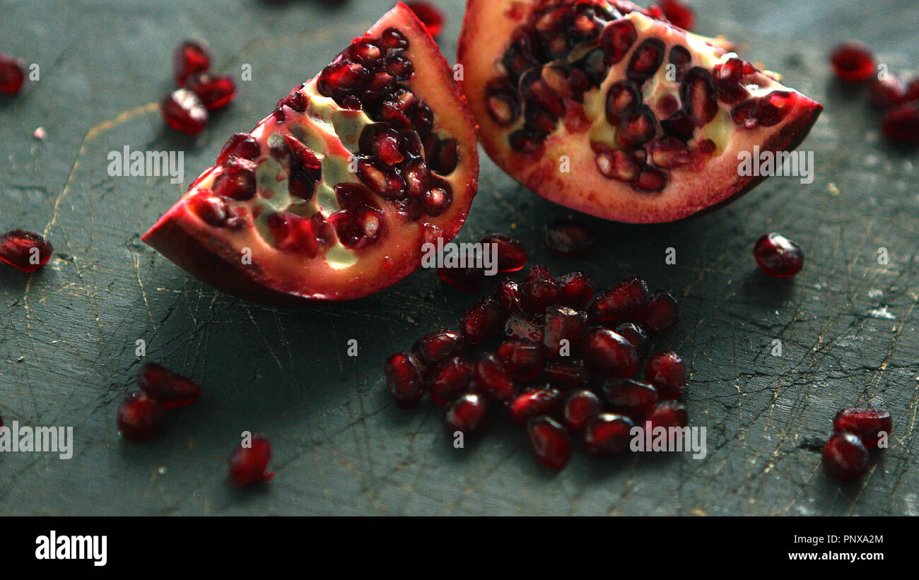 Ripe pomegranate halves on board Stock Photo