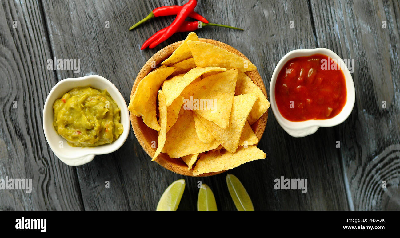 Served nachos with sauces on table Stock Photo