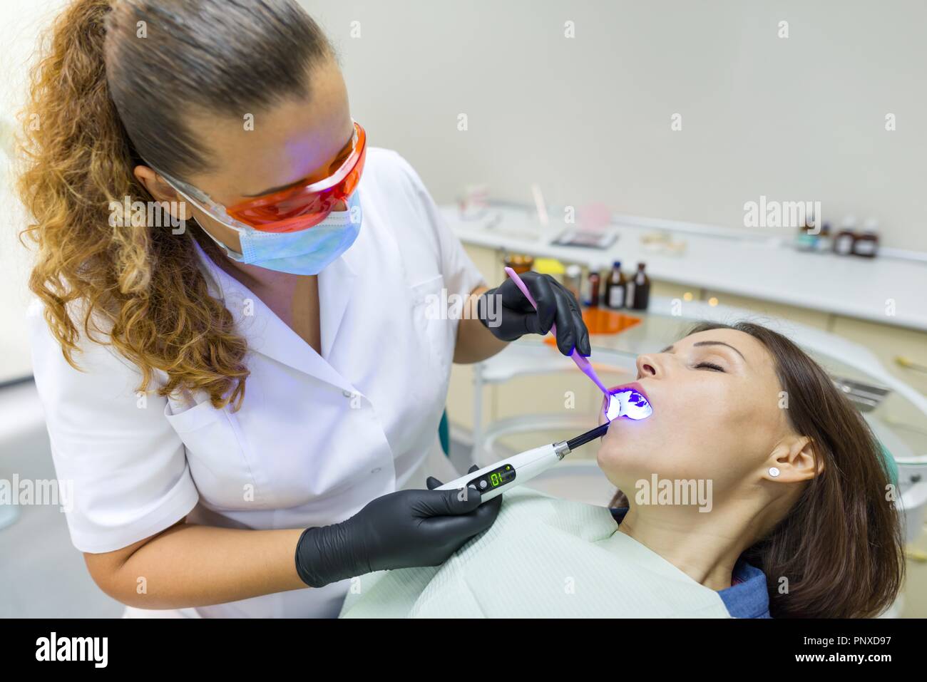 Adult female dentist treating patient woman teeth. Medicine, dentistry