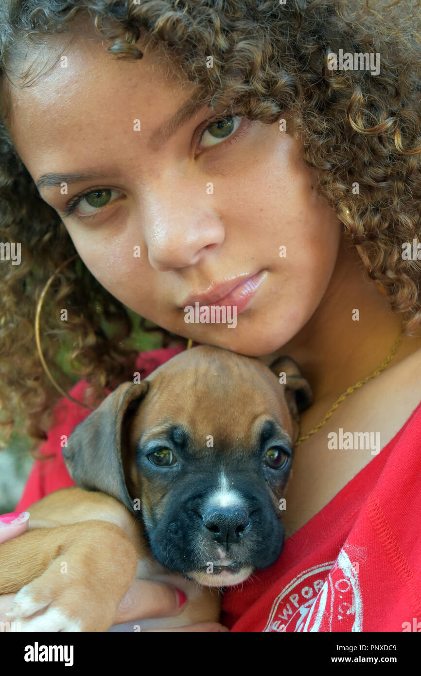 Mixed race teen girl holding a boxer puppy Stock Photo