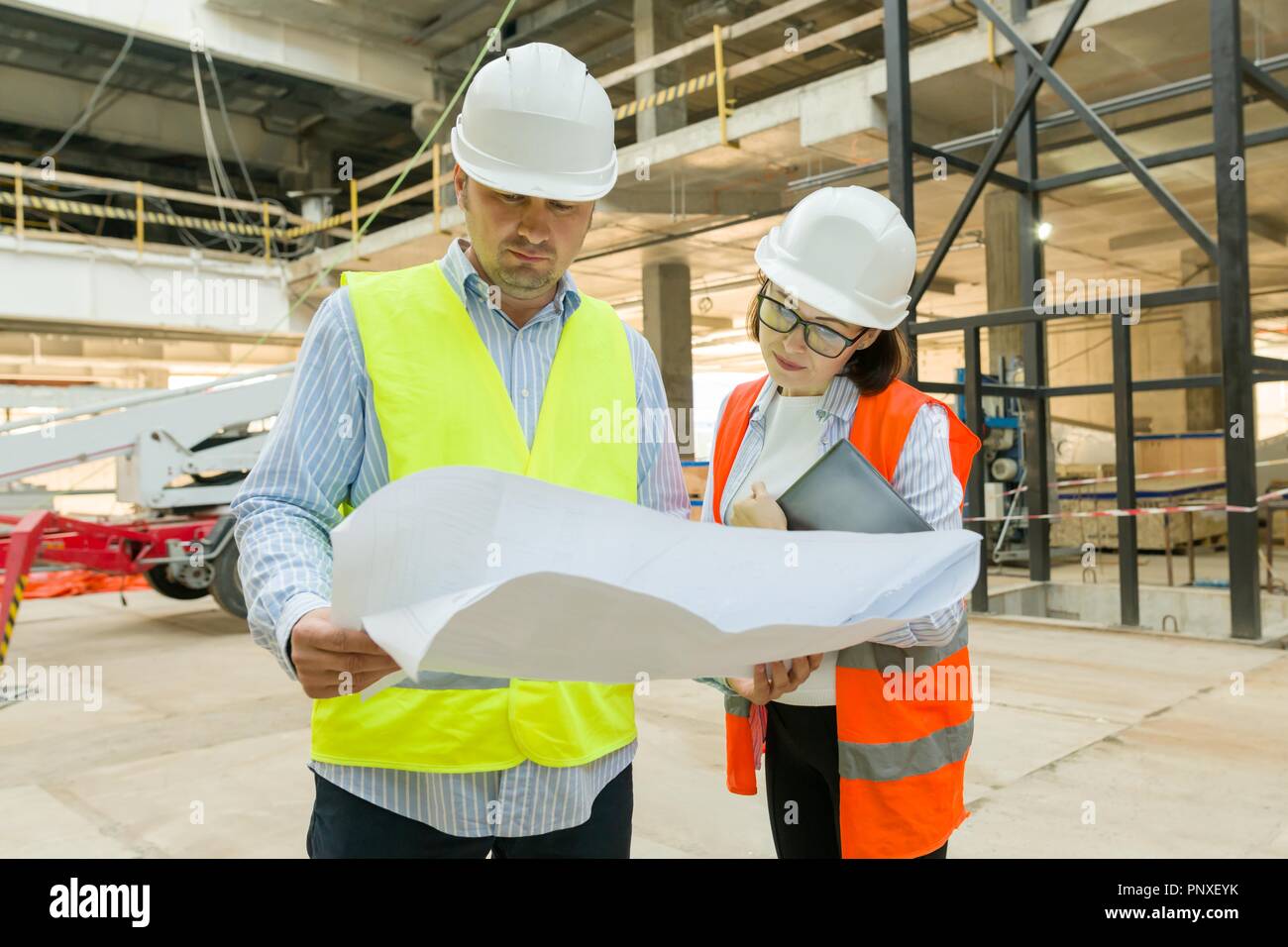 Man engineer and woman architect at a construction site. Building ...