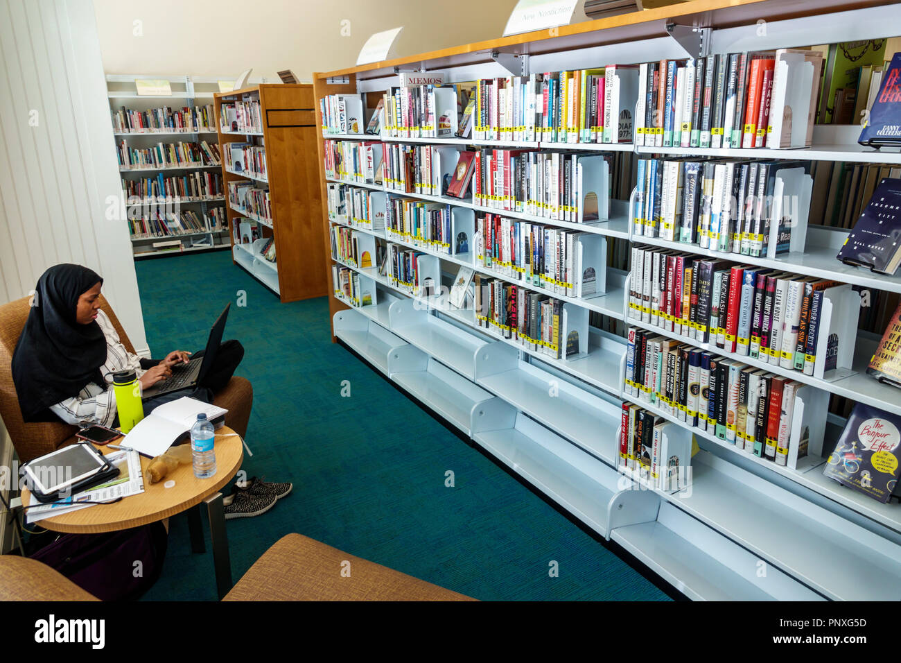 West Palm Beach Florida,Mandel Public Library,interior inside,books bookshelves,Muslim,Asian Asians ethnic immigrant immigrants minority,adult adults Stock Photo