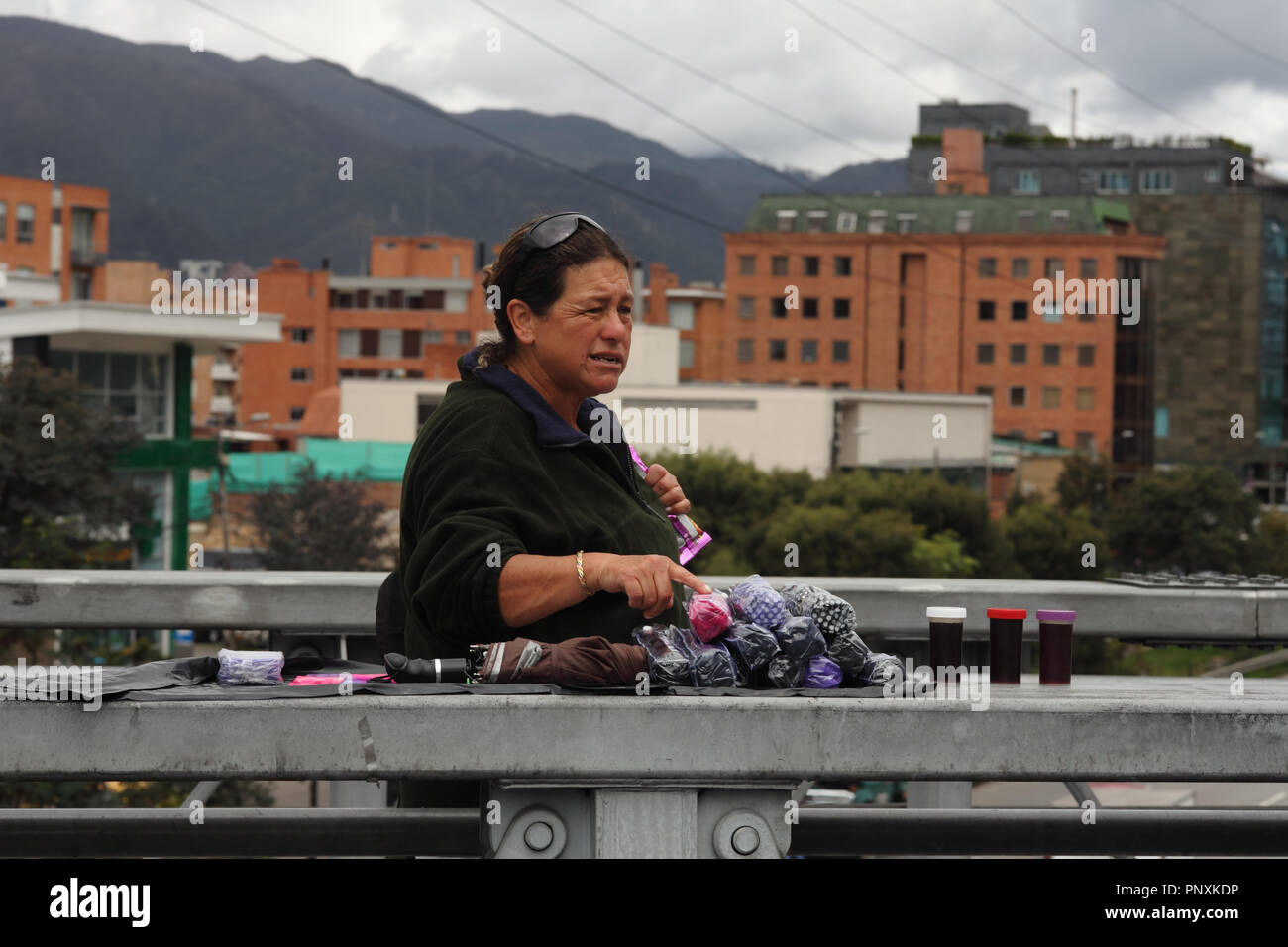 Bogota, Colombia - May 17, 2017: A commuter who uses the TransMilenio Bus Rapid Transit system on Calle 127, is seen ask for the price of umbrellas. Stock Photo