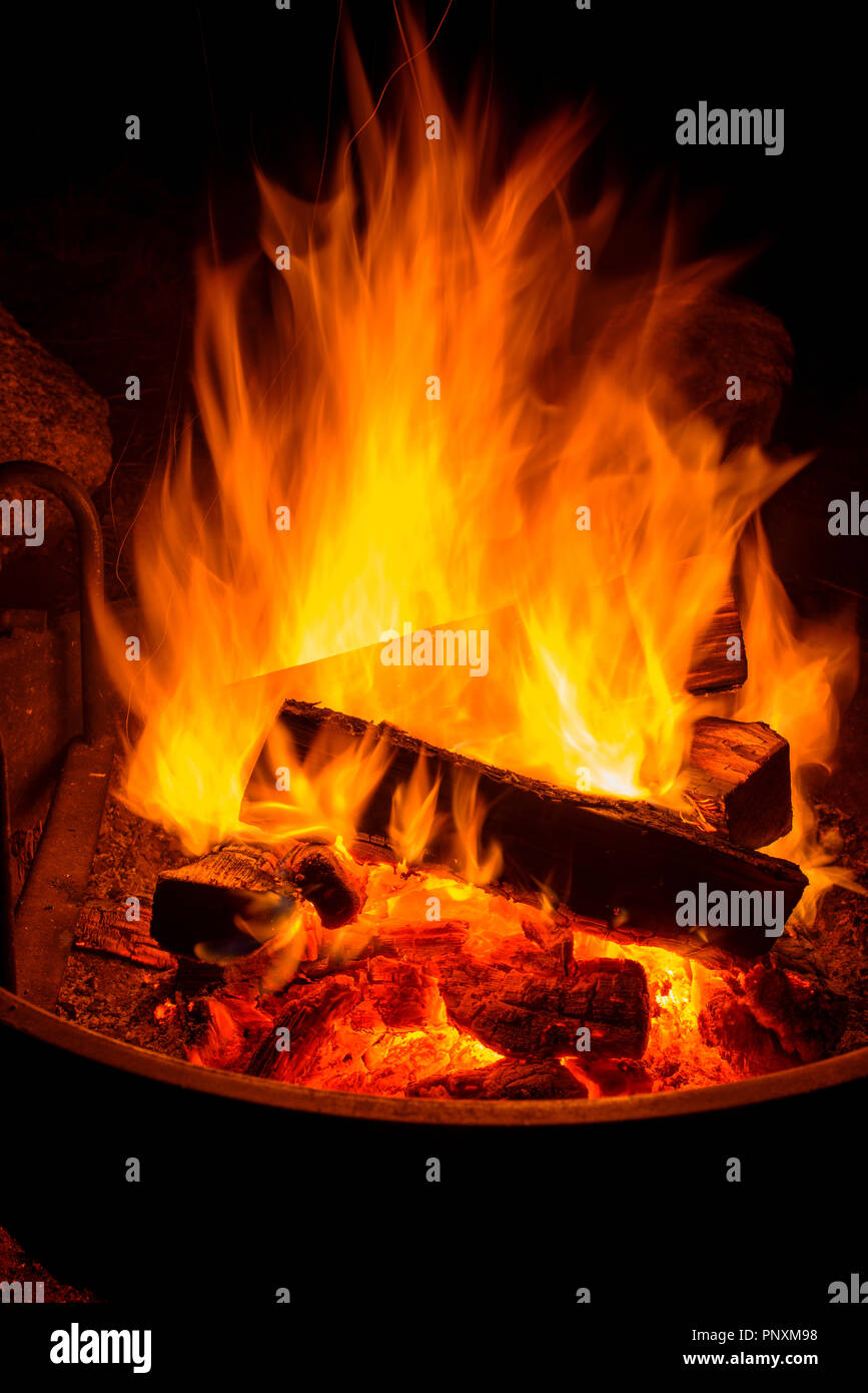 Campfire - Vertical - Close up view of blazing wood fire in a camp fire pit. Stock Photo