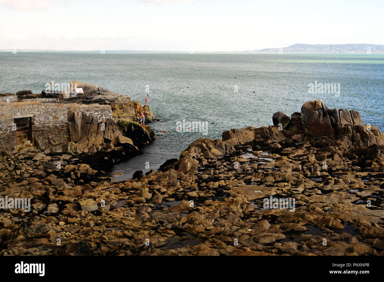 The famous Forty Foot at Sandycove, with Howth in the distance across Dublin Bay. Stock Photo