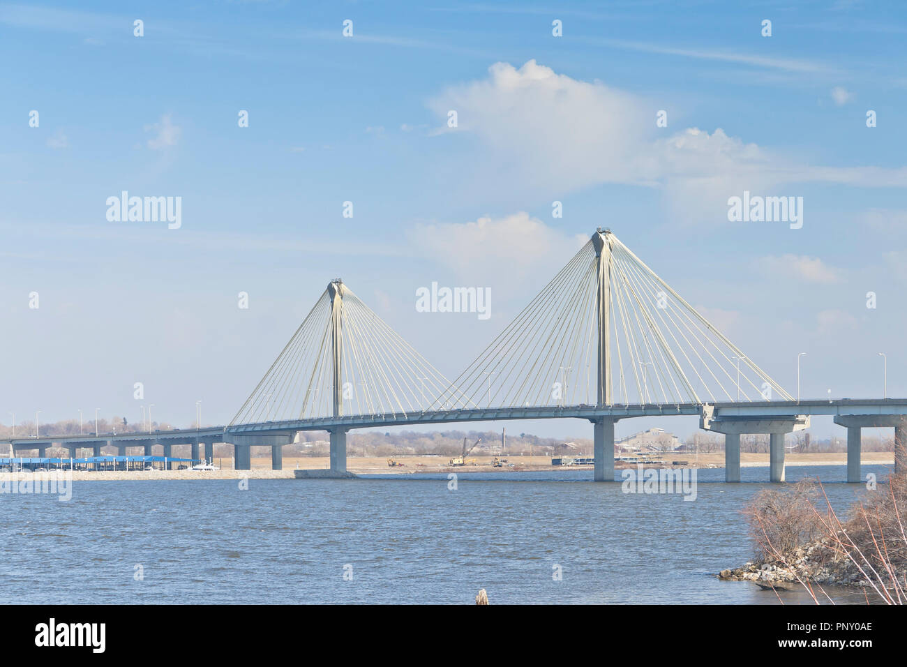 The Clark Bridge under droopy clouds and a pale blue sky seen from the Lincoln-Shields Recreation Area on the Missouri side of the Mississippi River. Stock Photo