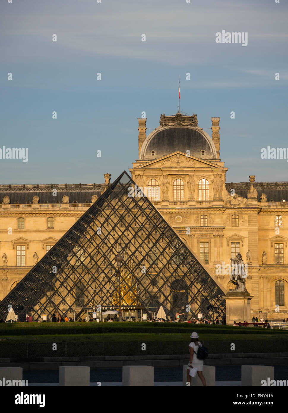 Tourist admiring the Louvre building at sunset Stock Photo