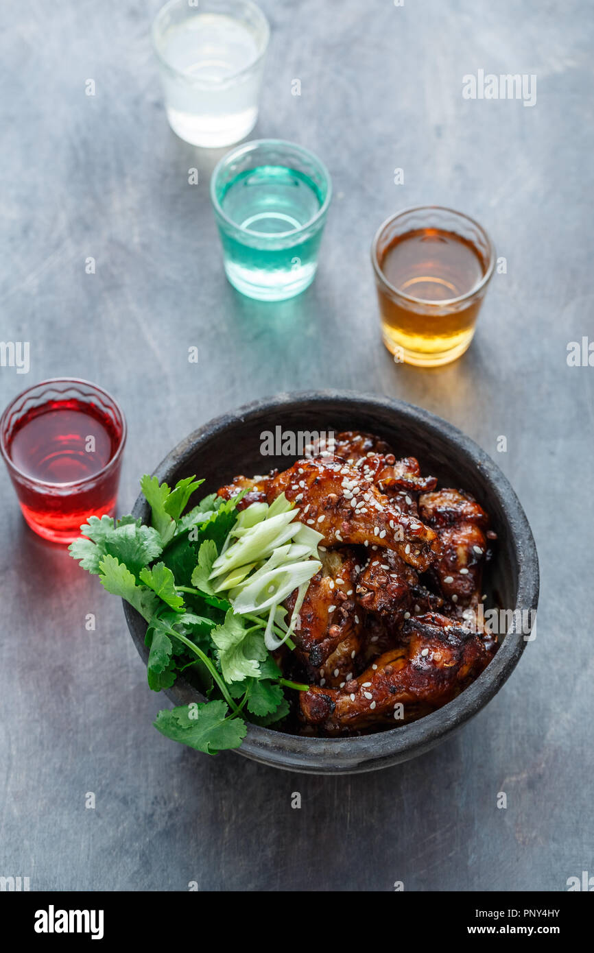 Spicy baked chicken wings in a bowl, dark background Stock Photo