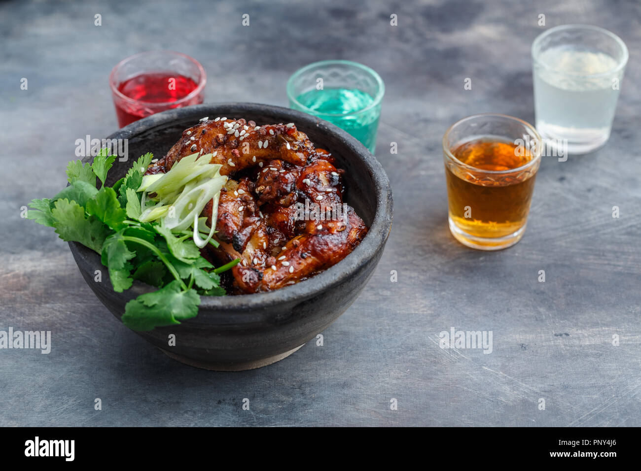 Spicy baked chicken wings in a bowl, dark background Stock Photo