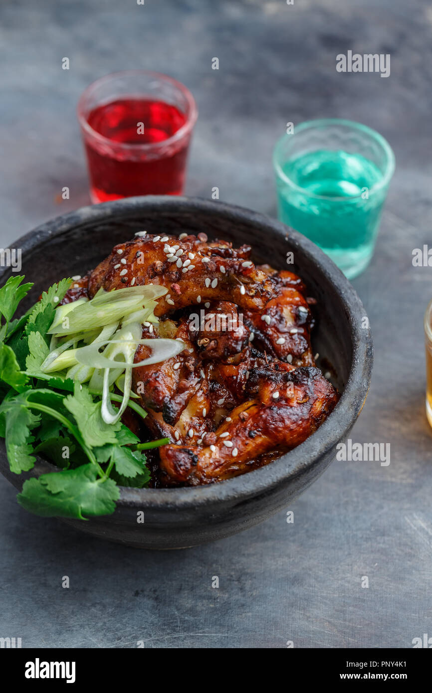 Spicy baked chicken wings in a bowl, dark background Stock Photo