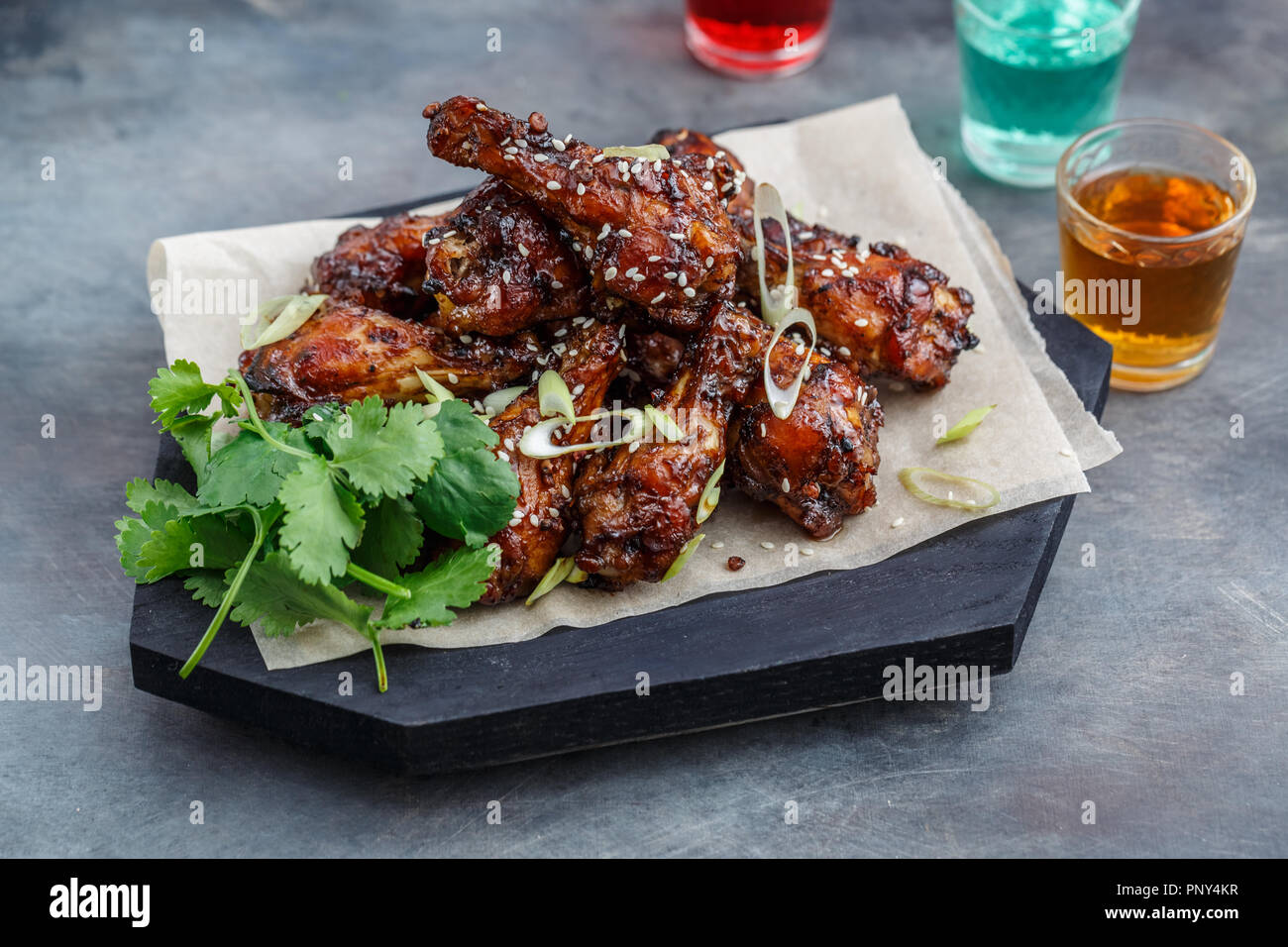 Baked chicken wings with sesame and sauce. Food background with copy space. Top view. Stock Photo