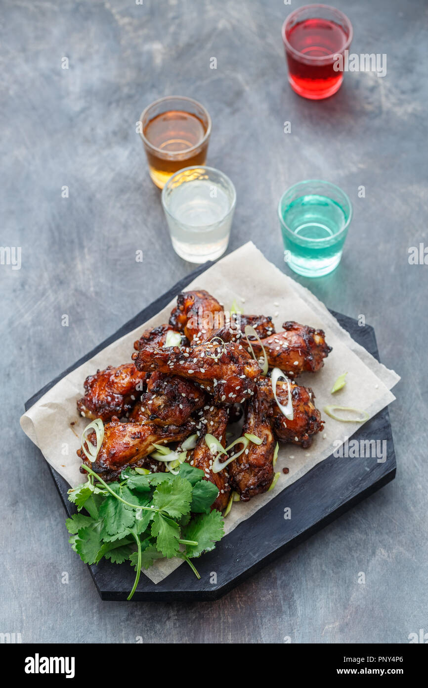 Baked chicken wings with sesame and sauce. Food background with copy space. Top view. Stock Photo