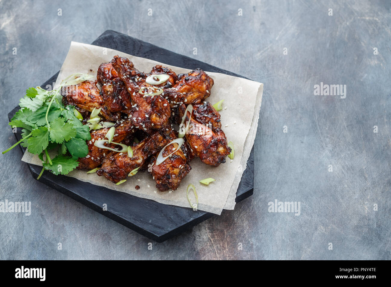 Baked chicken wings with sesame and sauce. Food background with copy space. Top view. Stock Photo