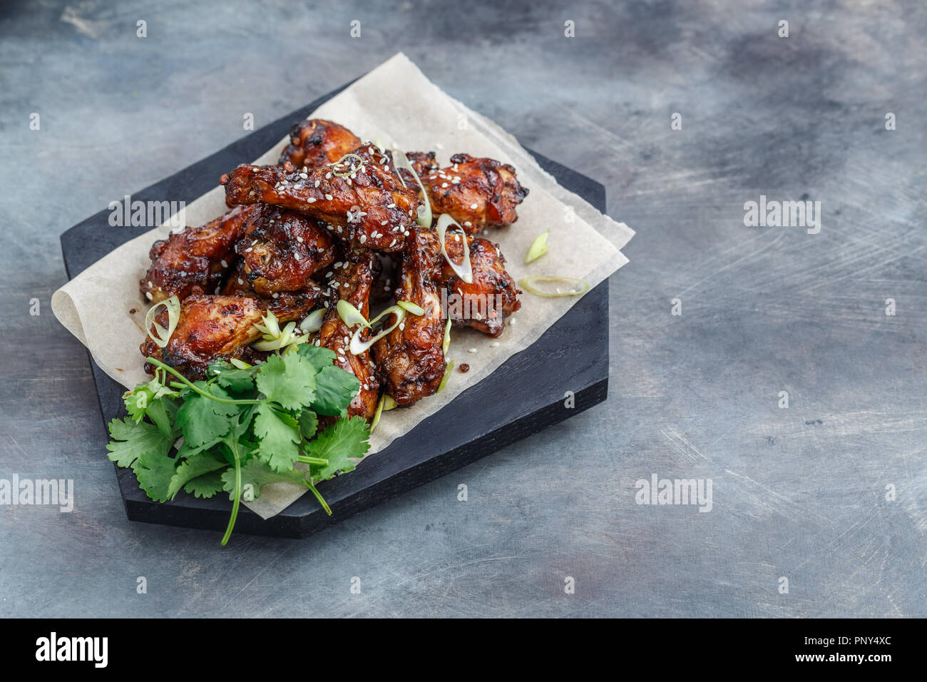 Sticky chicken wings with sesame, spicy sauce, copy space Stock Photo