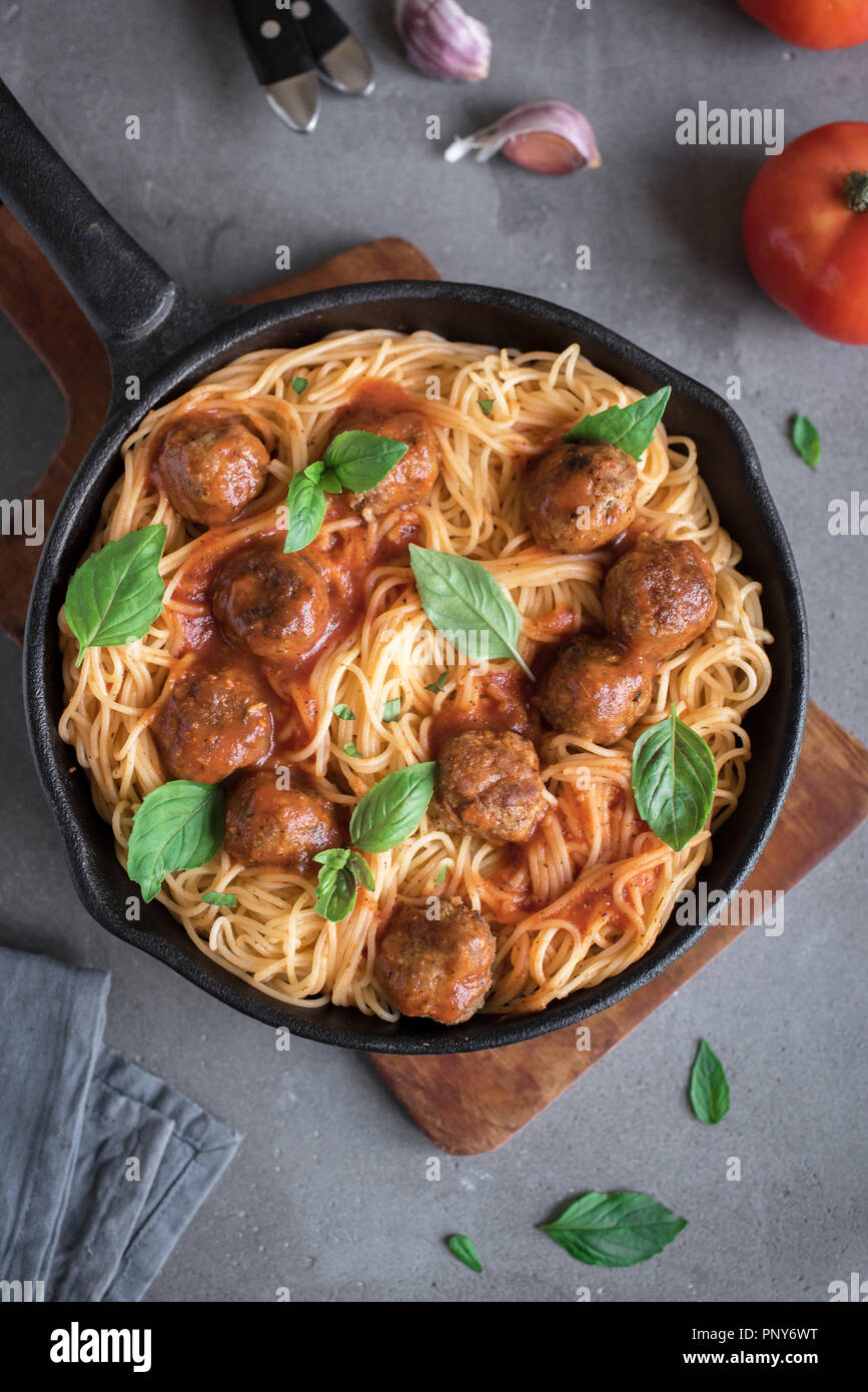Spaghetti pasta with meatballs, tomato sauce and fresh basil in cast