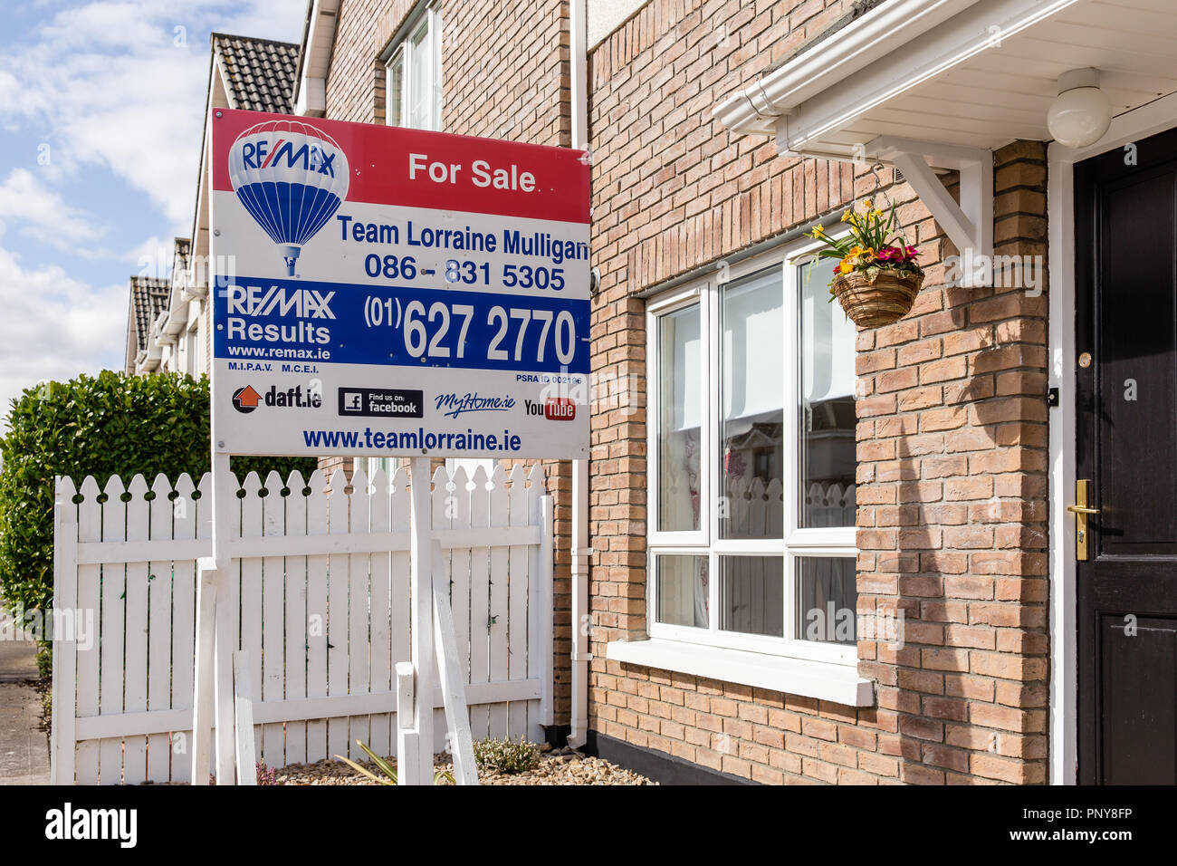 Property for sale sign standing in front of the terraced house Stock