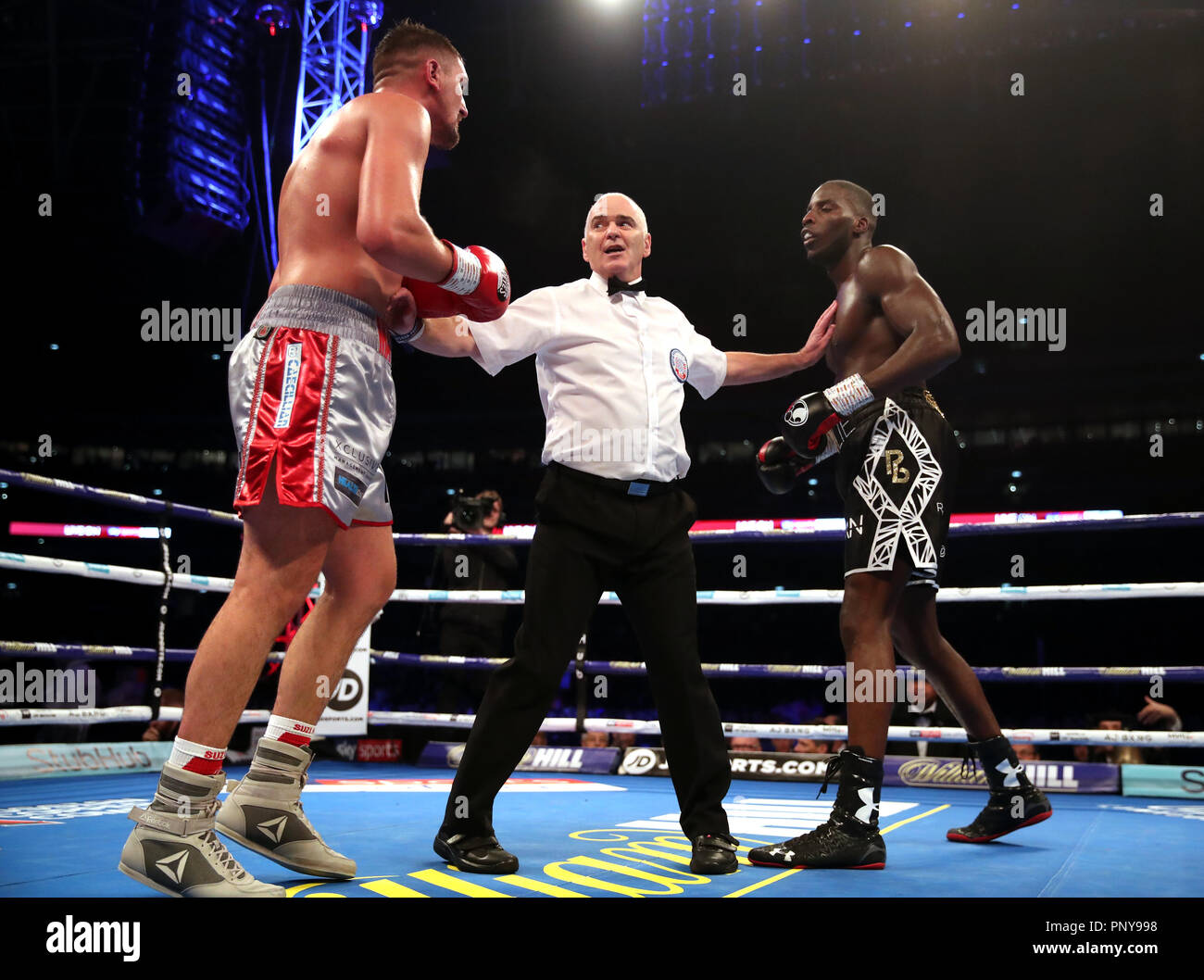 Matty Askin (left) and Lawrence Okolie (right) are separated by match referee Victor Loughlin (centre) at Wembley Stadium, London. Stock Photo