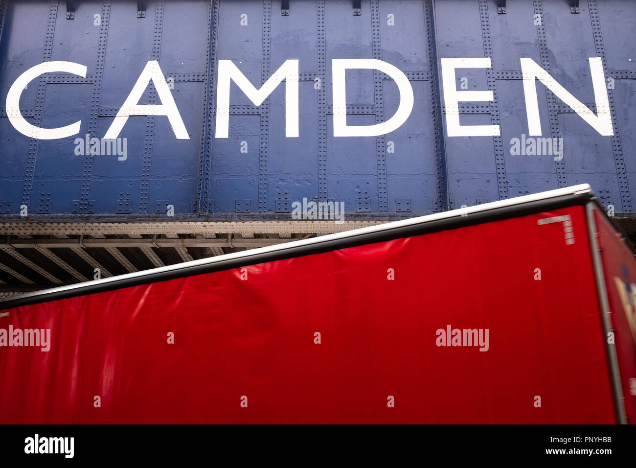 Red lorry passing below Camden Town Bridge, London, UK Stock Photo