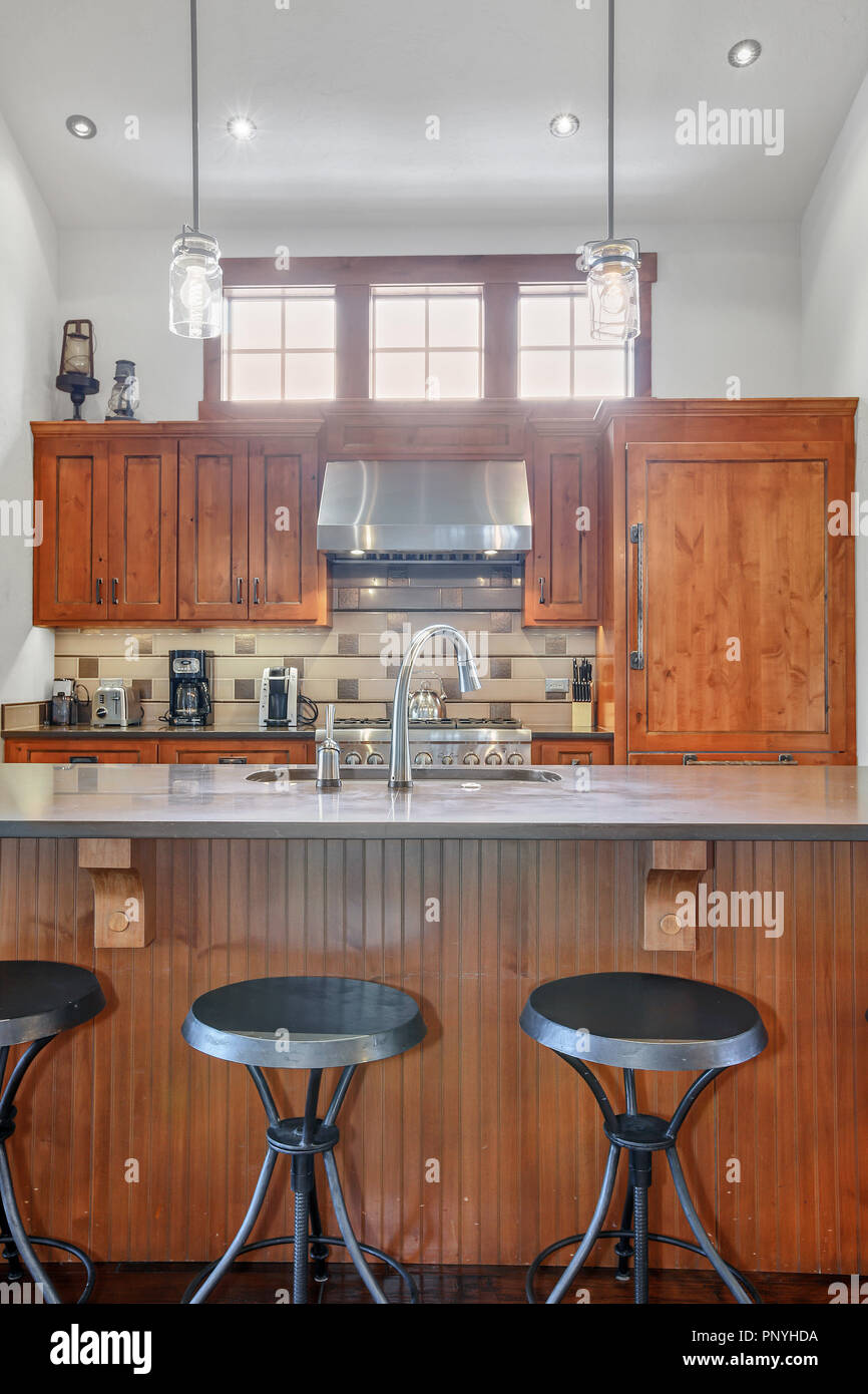 Lovely kitchen with stainless steel hood, wood cabinets and large center island. Stock Photo