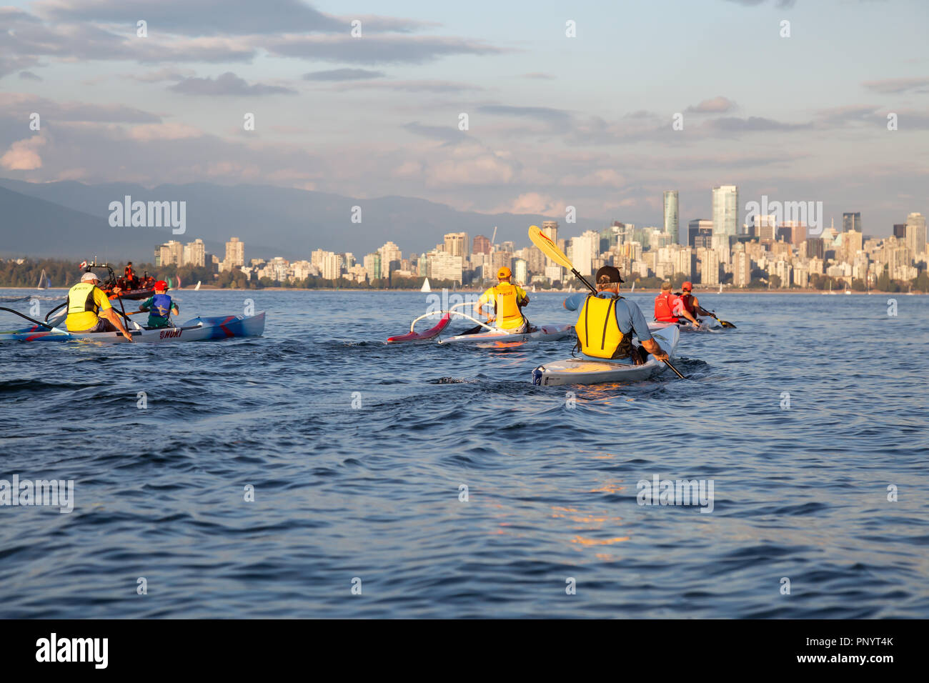 Vancouver, BC, Canada - August 30, 2018: People racing on Paddle Boards and Surf Ski during a vibrant summer sunset. Stock Photo