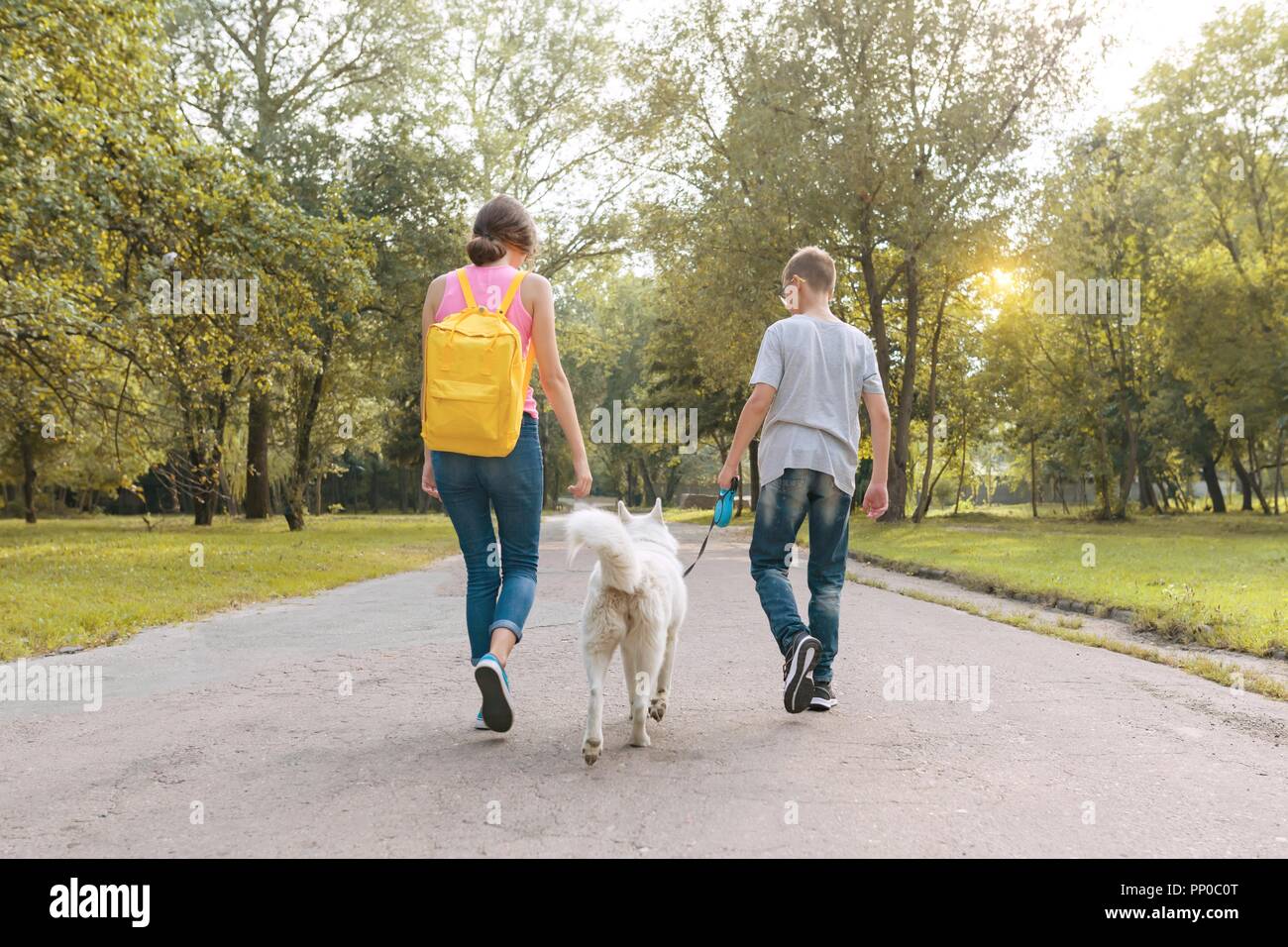 девушка на прогулке с собакой. прогулка с питомцем. гуляю с белой. фотосессия прогулка с собакой. девушка с собакой в парке.