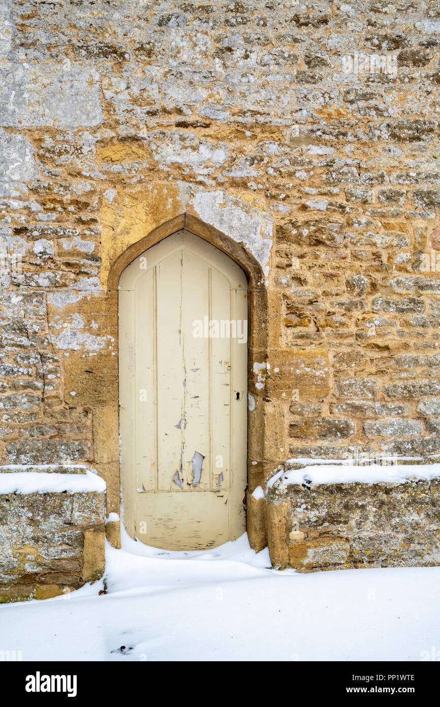 Stone arched door at Minster Lovell Hall ruins in the winter snow. Minster Lovell, Oxfordshire, England Stock Photo