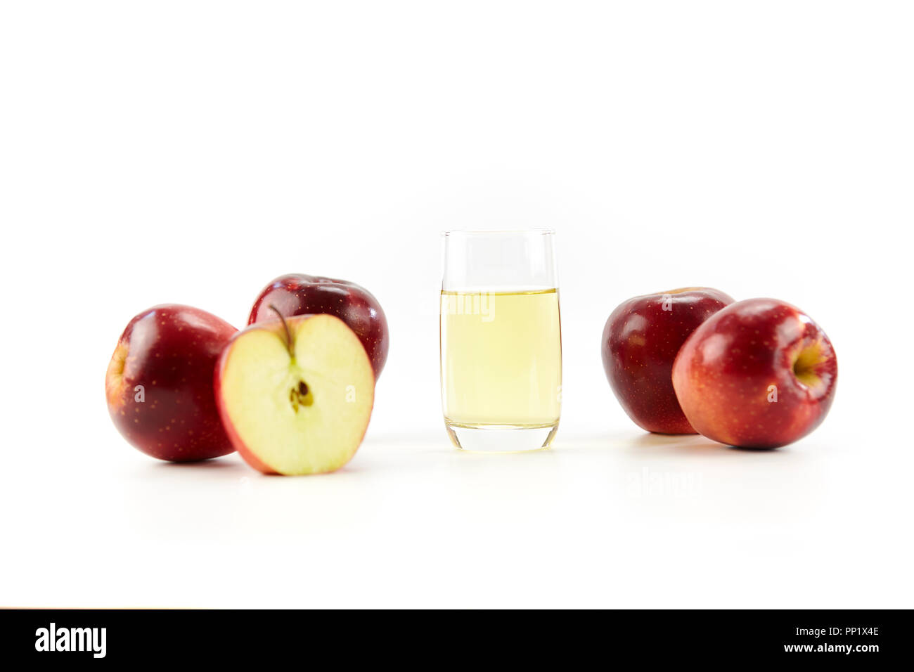 apples whole and half and a glass of apple juice isolated on white background. Stock Photo