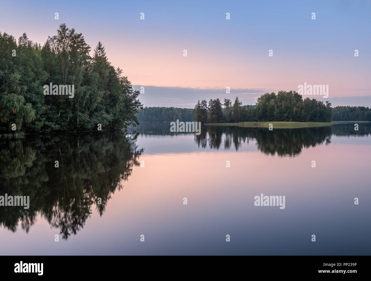 Scenic lake landscape with sunset and beautiful reflections at autumn evening in Finland. Stock Photo