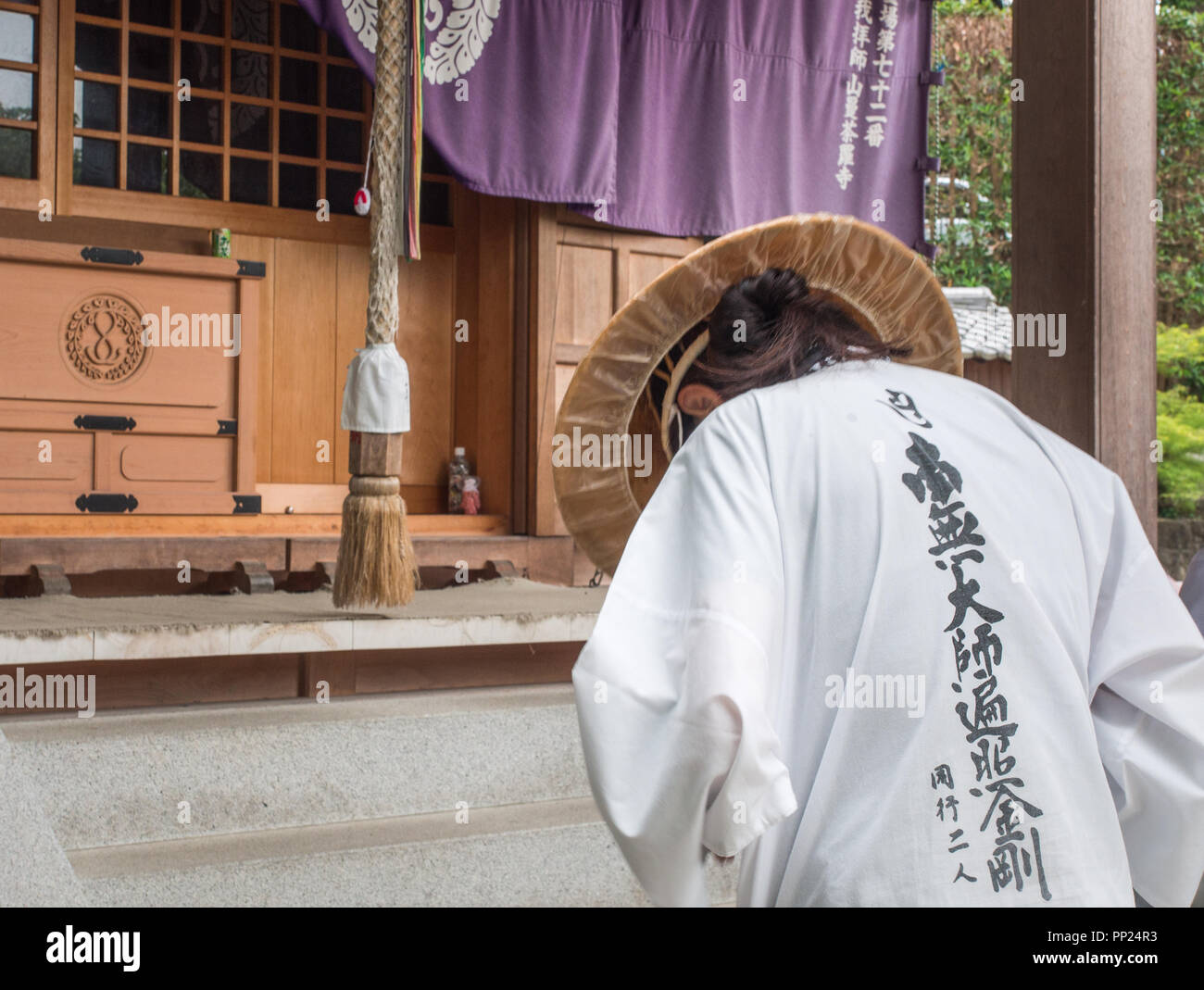 Henro pilgrim bowing in prayer, Mandaraji temple 72 Shikoku 88 temple pilgrimage, Kagawa, Japan Stock Photo