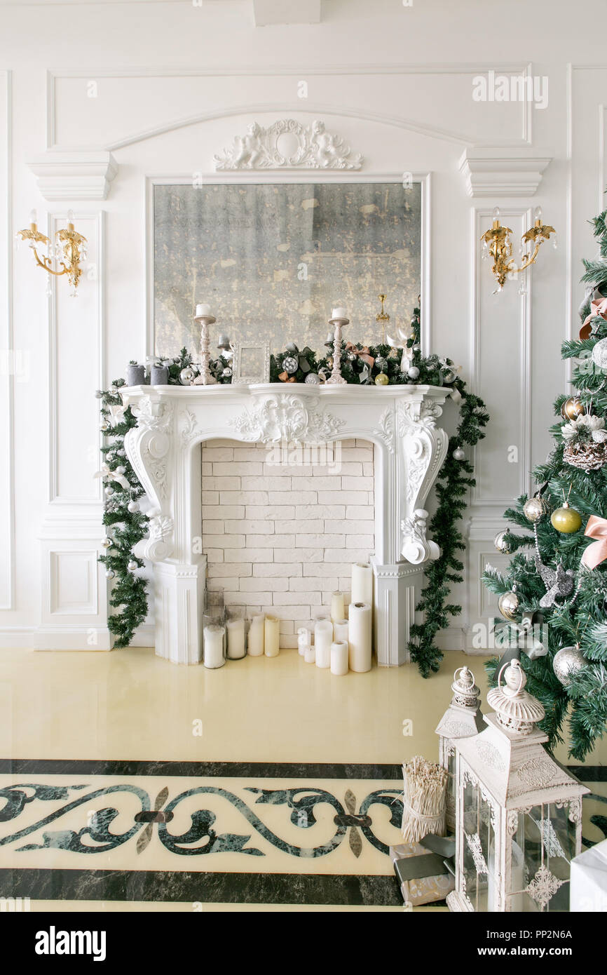 White Fireplace Decorated With Candles And Fir Branches Decorated