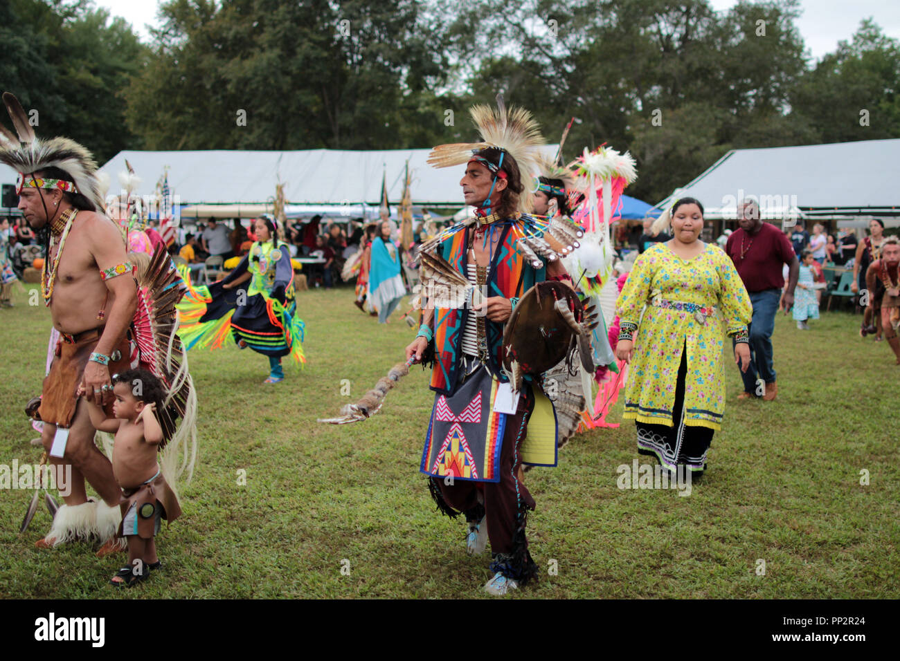 Native American performers dressed in traditional costumes dancing at