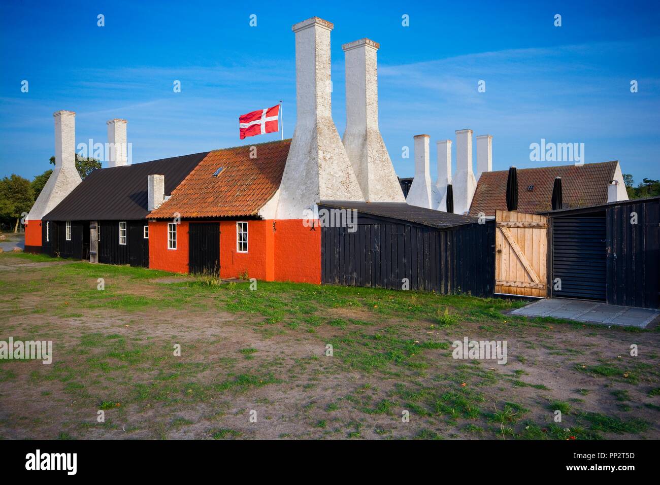Old traditional smokehouses with characteristic chimneys in Hasle, Bornholm, Denmark. This is the place, where you can taste the most popular dish on  Stock Photo