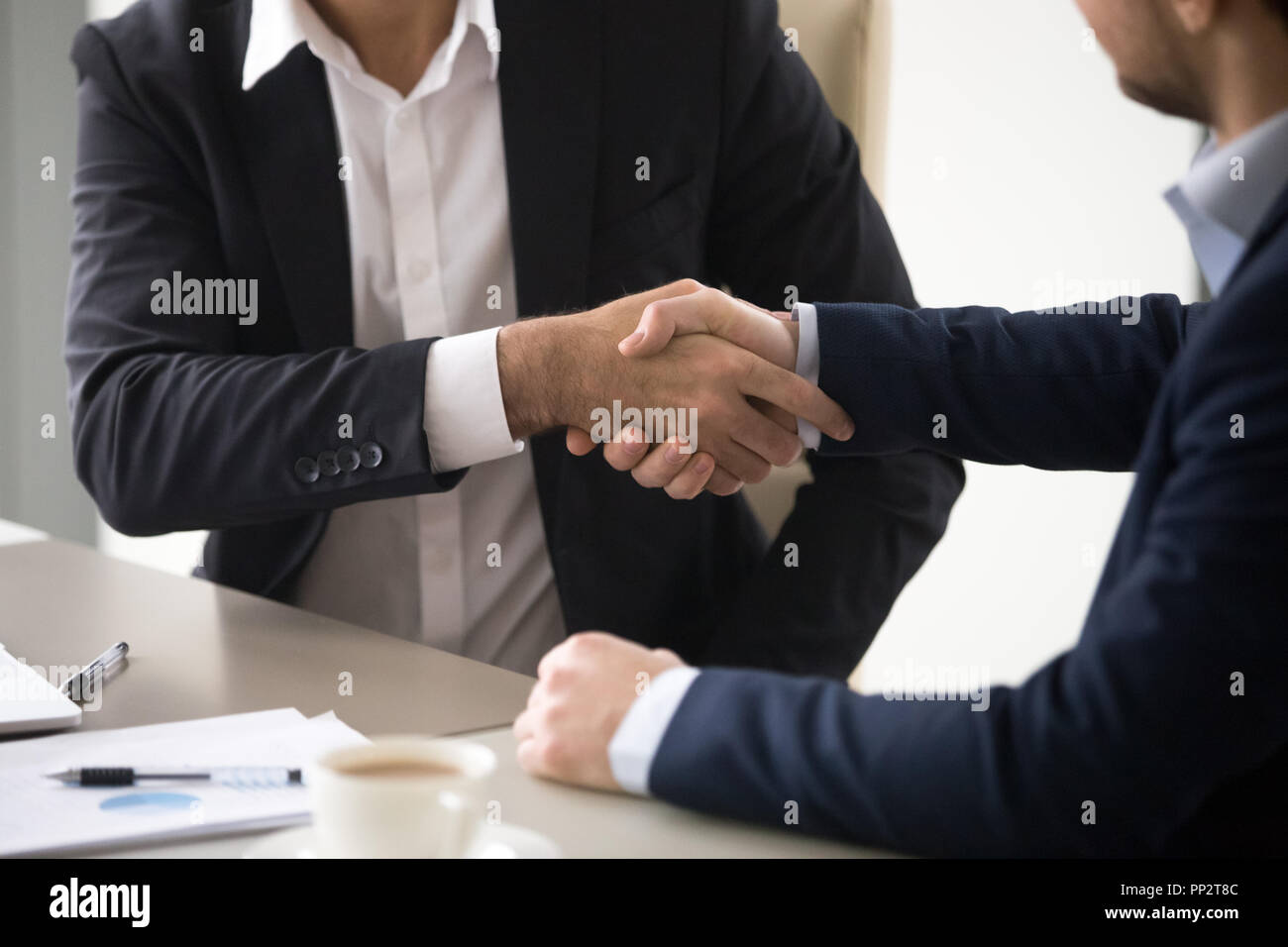 Close up of business partners shaking hands during meeting Stock Photo