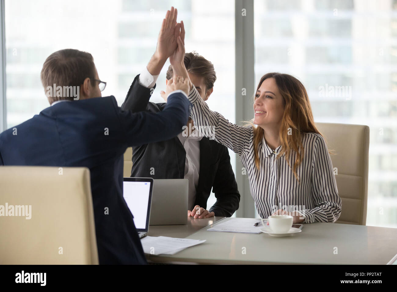 Workers giving high five motivating for success Stock Photo - Alamy