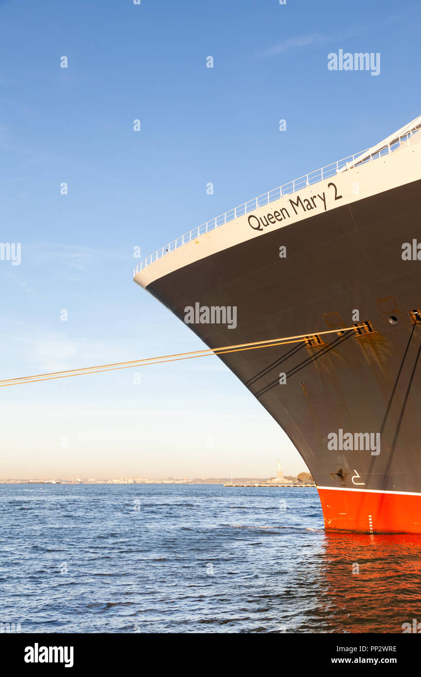 Cunard cruise liner Queen Mary 2 is pictured docked in Brooklyn, New York.  The Statue of Liberty can be seen in the background. Stock Photo