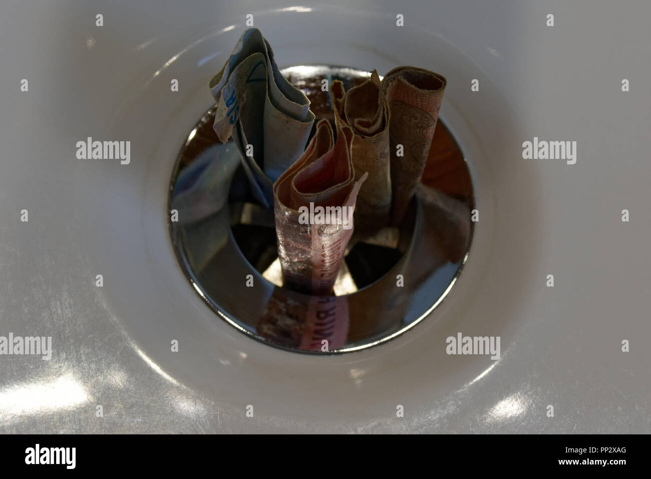 Throwing money down the drain hires stock photography and images Alamy