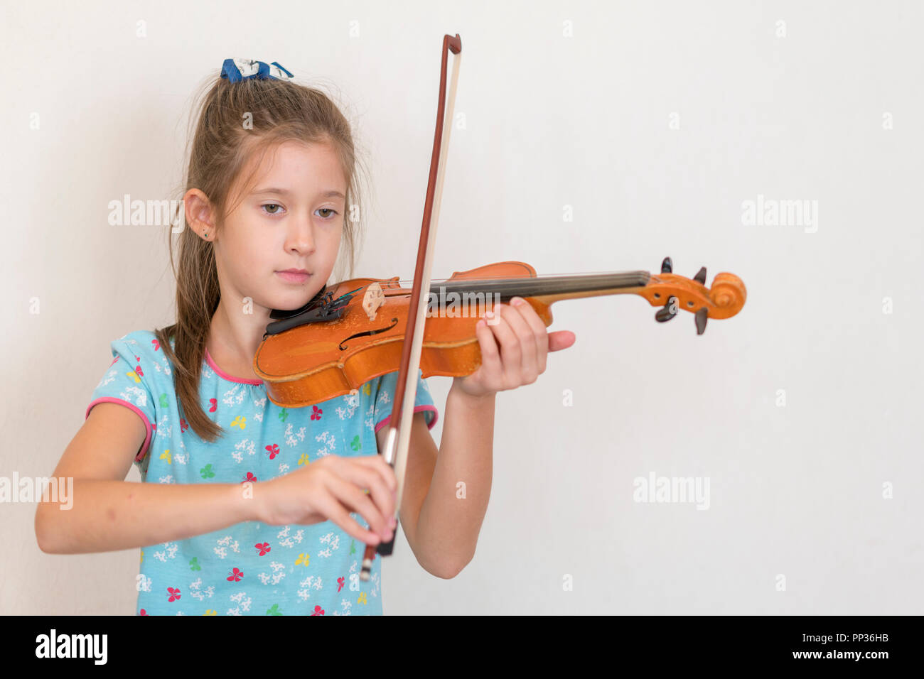 Cute pupil playing violin in classroom at the elementary school. Girl ...