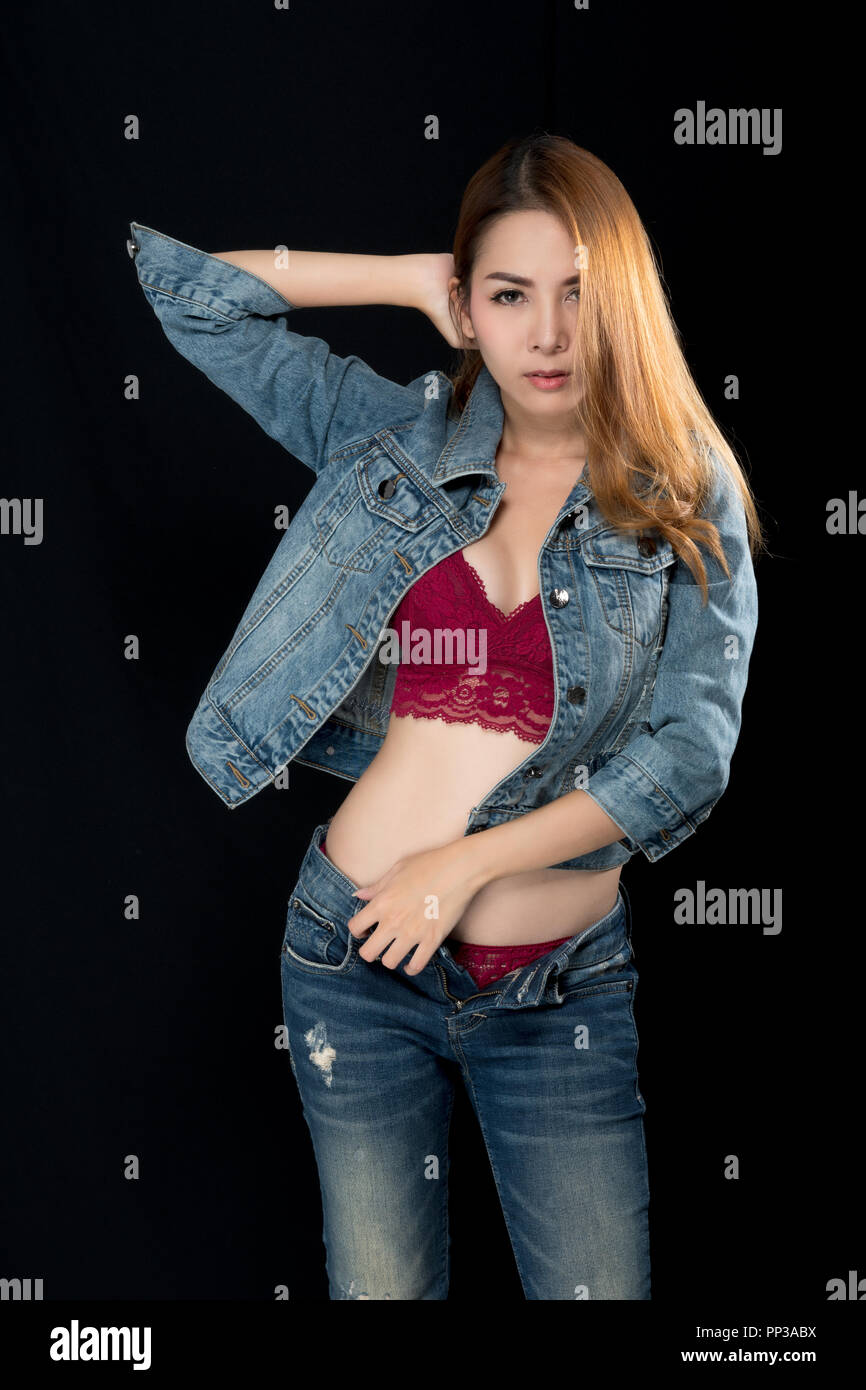 Asian girl in sexy jeans shows red lingerie on black background Stock Photo  - Alamy
